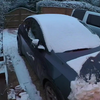 Zoontje moet als klusje het sneeuw van papas auto verwijderen