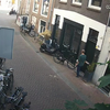 Lafbek jat fiets met kinderzitje voor deur in Amsterdam