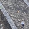 Vrouw beklimt verboden trap van pyramide