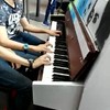 Tweeling speelt samen piano