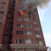 Vrouw hangt uit brandende flat